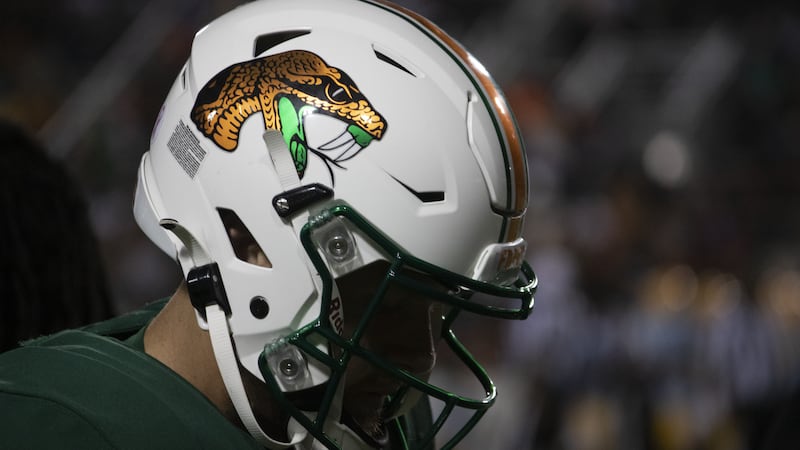 A FAMU Rattlers football player wears a white helmet on the sidelines of Bragg Memorial Stadium