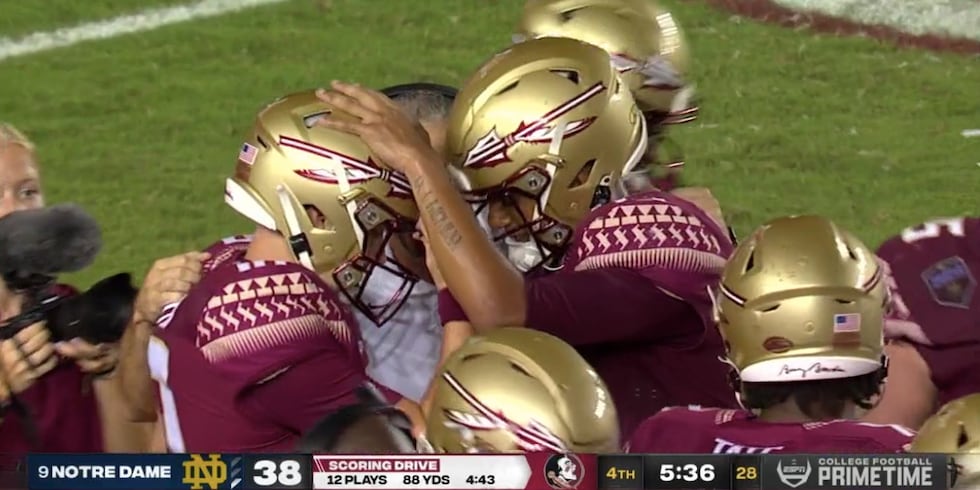 Jordan Travis congratulates McKenzie Milton after leading a touchdown drive