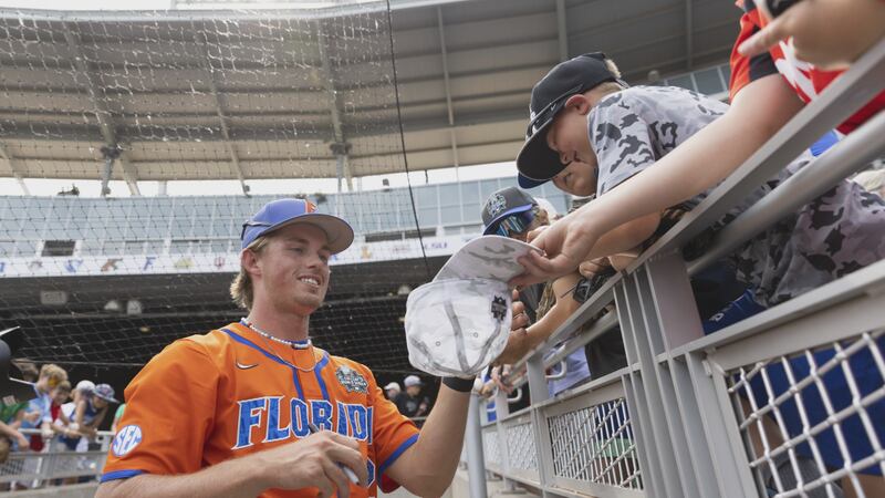 Florida's Hurston Waldrep signs autographs for fans following their 3-2 win against TCU in a...